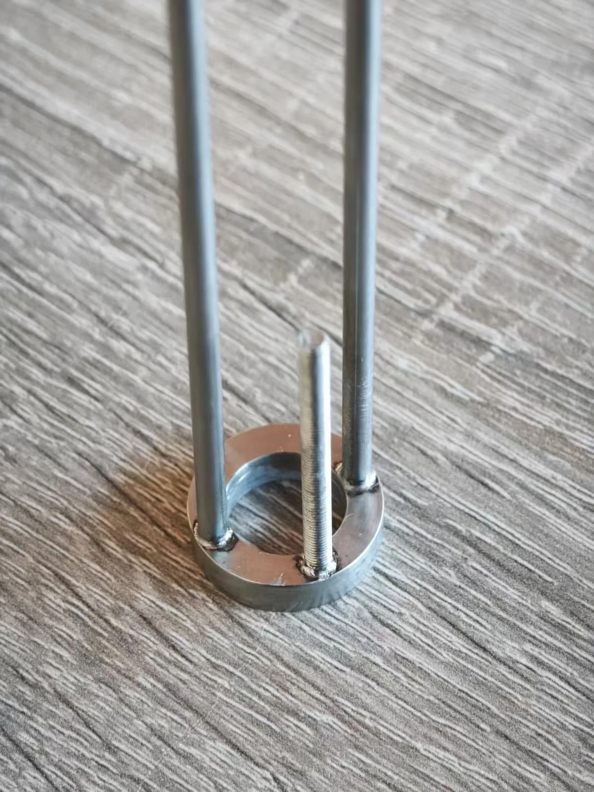 Close view of localized weld joints connecting rods to a circular metal body