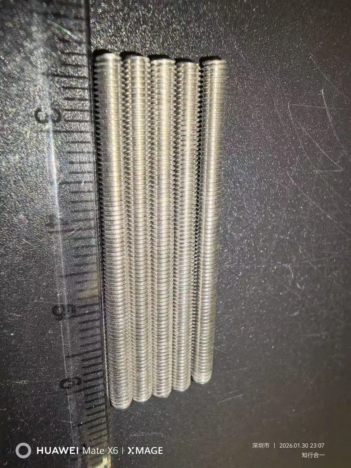 Separate small threaded rods photographed before welding and assembly
